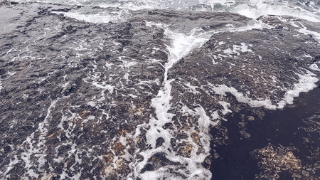 Sea waves breaking on the rocks in a stormy day. Aerial view