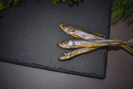 dried fish on a black stone plate, on a dark backgroundの写真素材