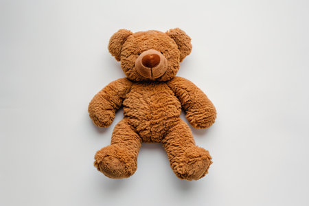 Brown teddy bear isolated on white background. Top view. Flat lay.の素材