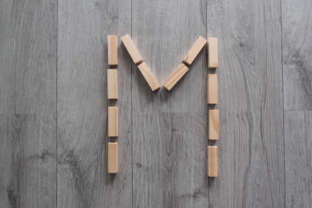 letter M with wooden natural blocks, construction, game for kids, no stress with wooden blocks, backgroundの写真素材