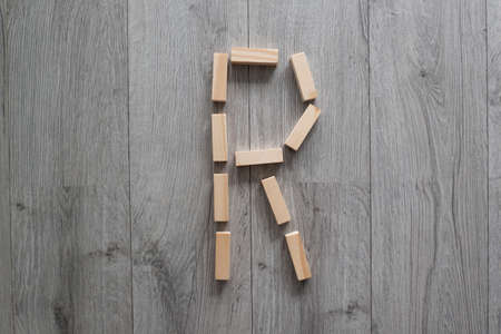 letter R with wooden natural blocks, construction, game for kids, no stress with wooden blocks, backgroundの写真素材