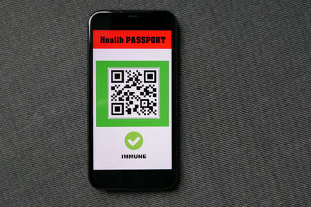 smartphone on gray background with digital health passport app for travel immuneの写真素材