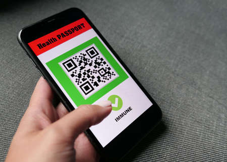hand with smartphone with digital health passport app for travel  immune vacinaの写真素材