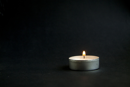 background  lonely candle on a dark black textureの写真素材