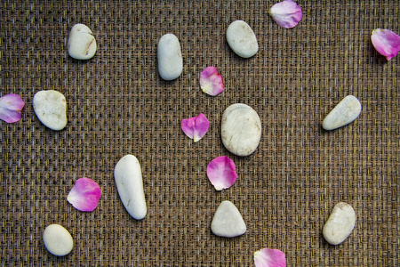 Pink rose bouquet and petals, round sea stones for spa, on wooden rustic backgroundの写真素材