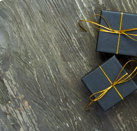 small different Christmas gift boxes on a rustic wooden backgroundの写真素材