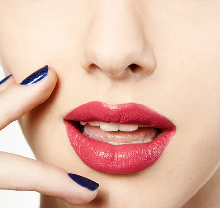 woman close up with pink lipstick red and blue nail polishの写真素材
