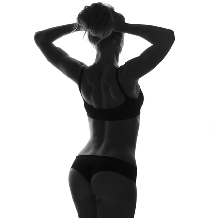 Sexy slim fit woman body. Muscled abdomen. Sportswear. Isolated on white. Black and white imageの写真素材