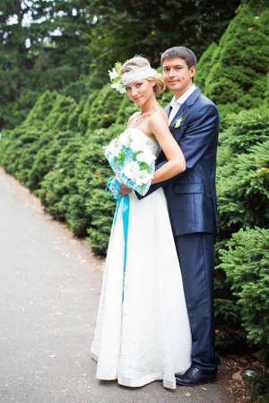 Young couple in wedding gown. Bride holding bouquet.の写真素材