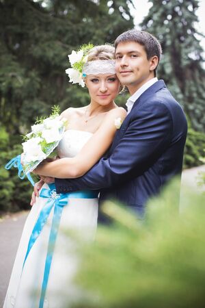 Young couple in wedding gown. Bride holding bouquet.の写真素材