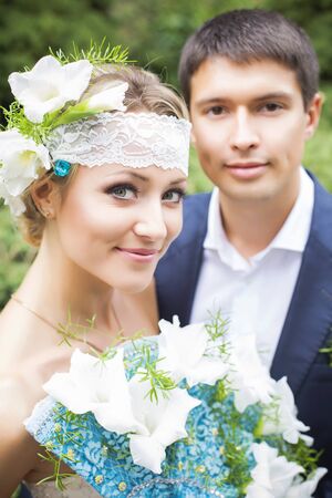 Young couple in wedding gown. Bride holding bouquet.の写真素材
