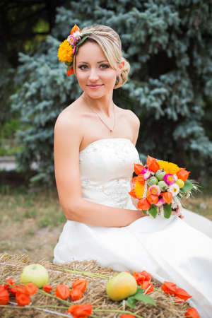 Blonde bride in white wedding dress holding bouquet and smilingの写真素材