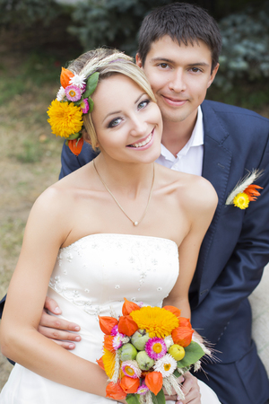 Young couple in wedding gown. Bride holding bouquet of flowers.の写真素材