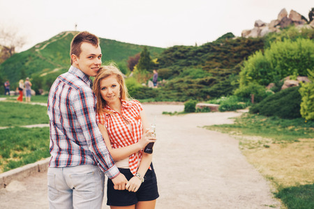 Beautiful loving caucasian couple on a date walking at the park. summer warm weatherの写真素材