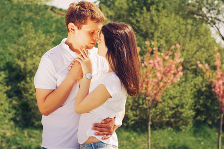Beautiful loving caucasian couple on a date walking at the park. summer warm weatherの写真素材