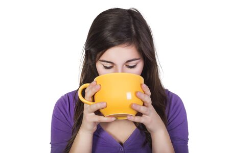 Brunette woman drinking beverage from a big yellow cup isolated on white. copy spaceの写真素材