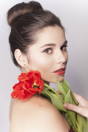 Beautiful Brunette Woman Portrait With Tulips and Red Lipstickの写真素材