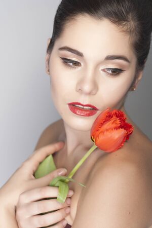 Beautiful Brunette Woman Portrait With Tulips and Red Lipstickの写真素材