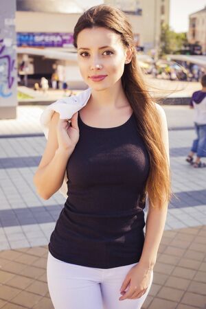 Beautiful brunette business woman in white suit and black t-shirt outdoorsの写真素材