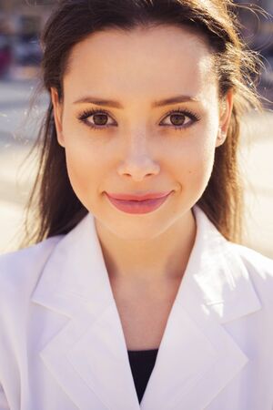 Close up portrait of a Beautiful brunette business woman in white suit outdoorsの写真素材