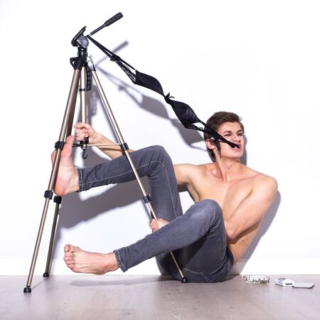 Brunette man do crazy fun in jeans and underwear on a floor. indoorsの写真素材