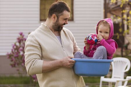 Little girl kid playing, having fun with mother and father. outdoors