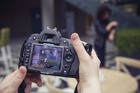 Photographer shooting a beautiful brunette woman on a walk on european city street in daylight. outdoorsの写真素材