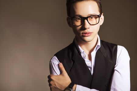 Young handsome brunette macho businessman in black suit and white shirt and glasses. neutral backgroundの写真素材