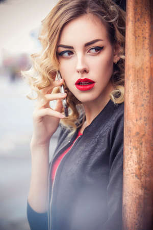 Beautiful brunette sexy spy agent (killer or police) woman in leather jacket and red luxury dress...