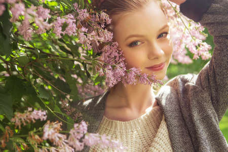 Beautiful red hair ginger slim young woman with fresh skin in casual outfit, posing with flowers....
