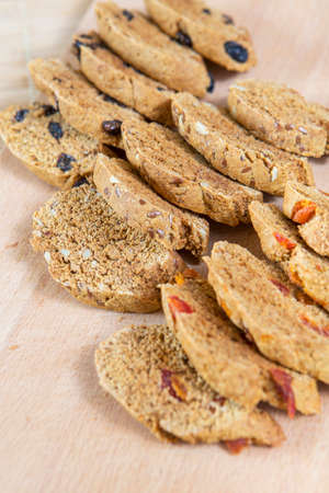 Homemade tasty biscotti with raisins and dried fruits. Italian traditional receipt. Healthy no sugar food. Wooden backgroundの写真素材