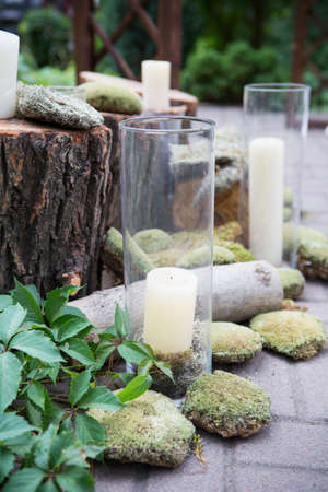 Stumps decorated with moss and candles in garden, on a wedding ceremony. Soft day light, outdoorの写真素材