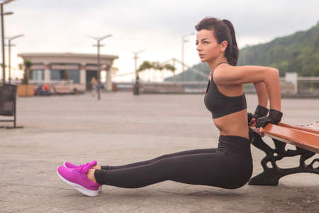 Brunette slim adult sexy fit sporty caucasian woman in sportswear on a european city streets in...