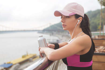 Brunette slim adult sexy fit sporty caucasian woman in sportswear on a european city streets in morning do exercises (workout). Copy spaceの写真素材