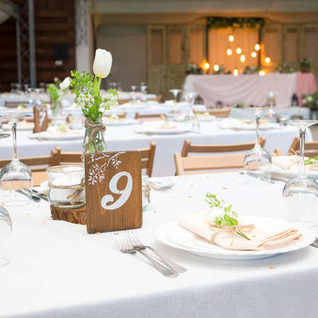 Simple but luxury rich table setting for a wedding celebration in nice cozy restaurant. Wineglasses,...