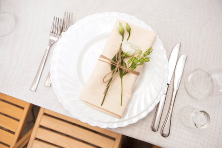 Simple but luxury rich table setting for a wedding celebration in nice cozy restaurant. Wineglasses,...