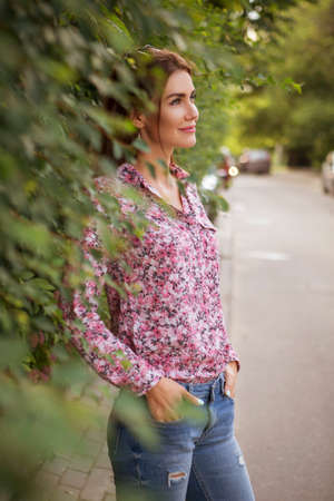 Cute beautiful slim brunette caucasian woman in casual hipster outfit on a walk in european city. Copy spaceの写真素材