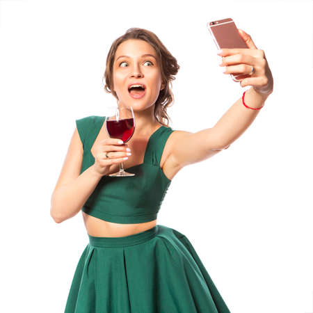 Brunette pretty beautiful caucasian woman in green festive dress blowing candle on a birthday party...