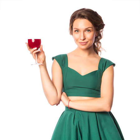 Brunette pretty beautiful caucasian woman in blue festive dress blowing candle on a birthday party cupcake. Isolated white backgroundの写真素材