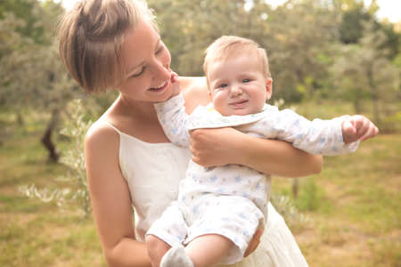 Cute happy caucasian woman with short haircut in white dress in park relaxing feeling good, smiling....