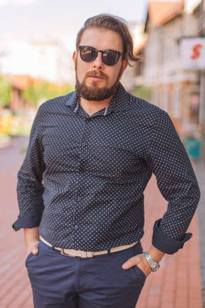 Happy caucasian man on a walk in european city, dressed in casual outfit. Summer daylightの写真素材