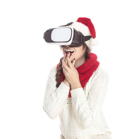 Cute teenage girl with long dark hair standing on a white background in white sweater, red gloves, trousers and hat. Emotional lifestyle portraitの写真素材