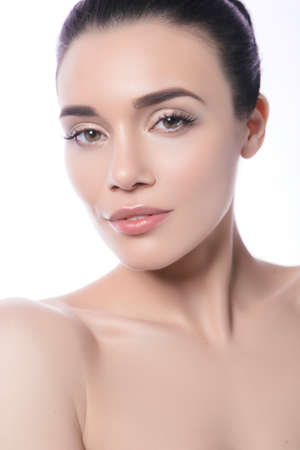Close up of a beautiful brunette caucasian woman with fresh clean natural skin and soft smile on her face. Neutral, daily make upの写真素材