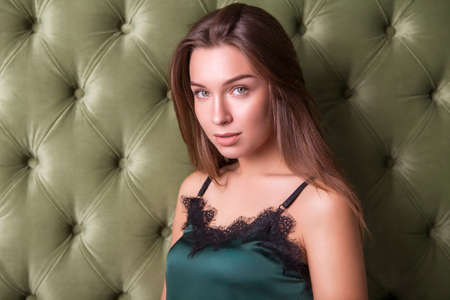 Young beautiful caucasian brunette woman sitting in casual clothes on a neutral background. Copy spaceの写真素材