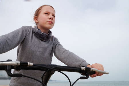 girl rides a bicycle along the sea