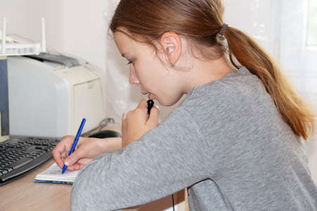 distance learning, a girl performs class work, talking on a microphone
