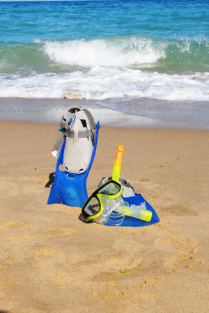 flippers and mask for swimming on the sand against the background of the sea and clear sky, copy spaceの写真素材