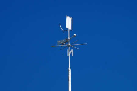 weather station weather vane close-up on a background of clear blue sky, copy space