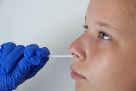 the doctor takes a test for coronavirus from the girl's mouth.