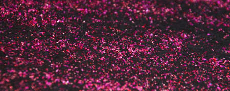dark pink shiny glitter on black background.の写真素材